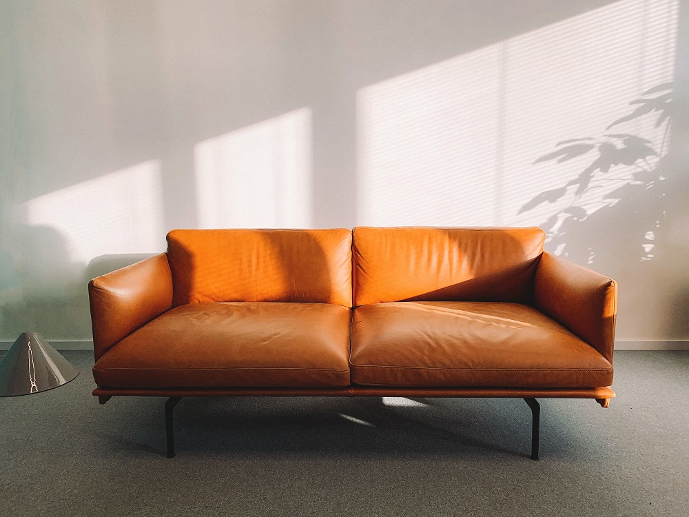 2-seat-orange-leather-sofa-beside-wall-1866149